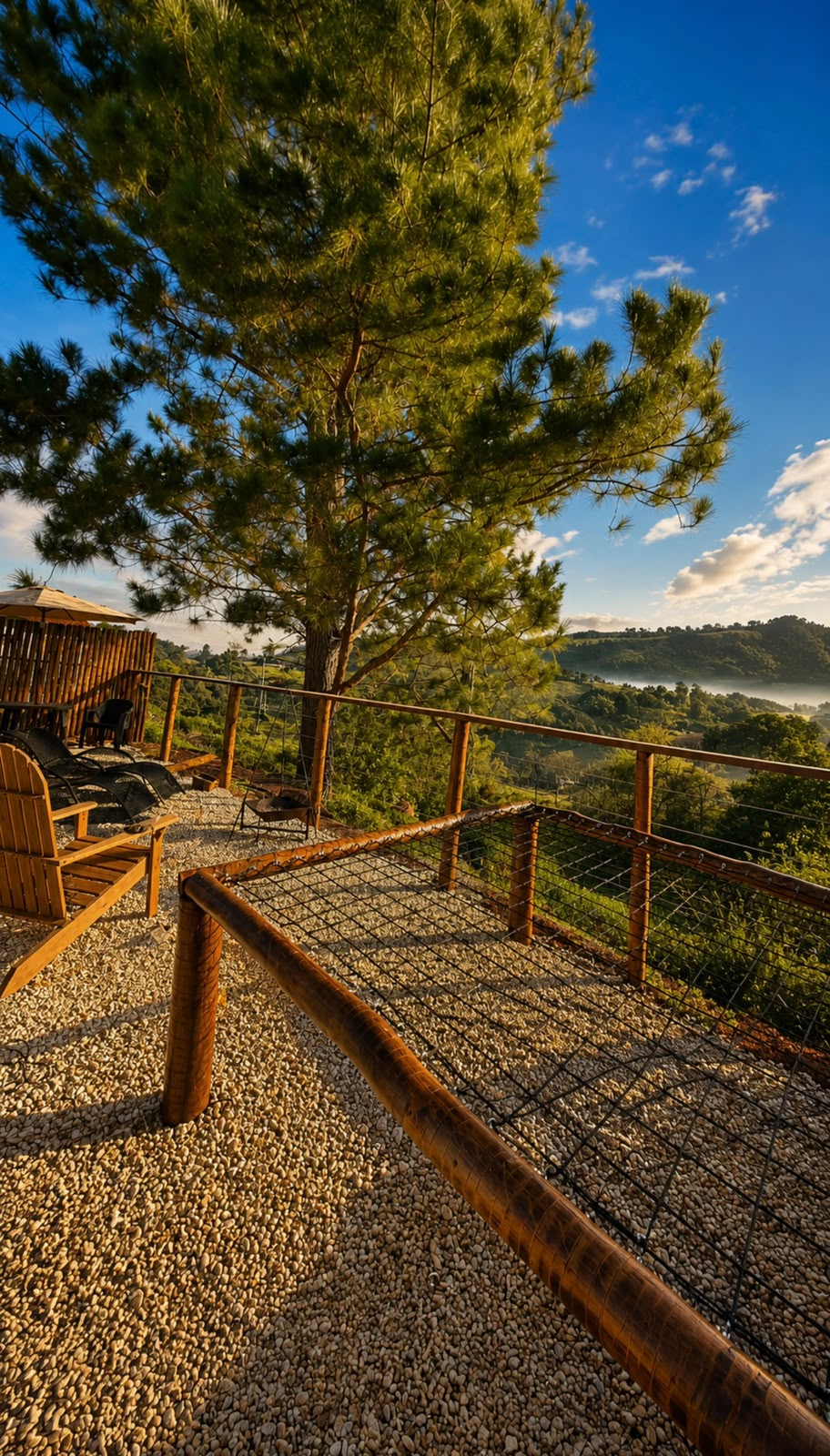Deck externo com rede suspensa e vista para o vale ao amanhecer